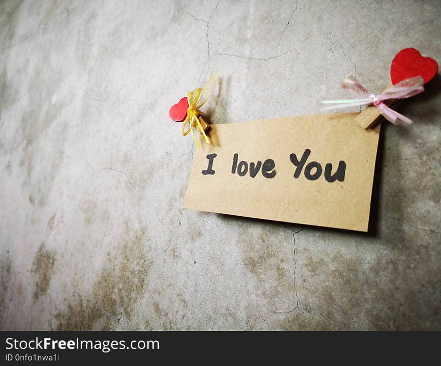 A note I Love You written on a piece of paper on the wall. A note I Love You written on a piece of paper on the wall