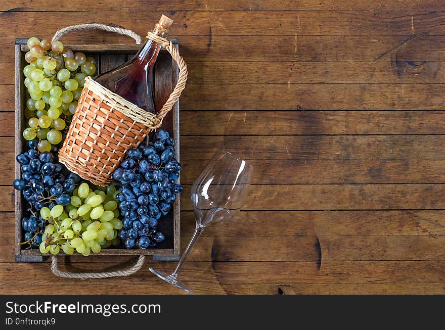 Wine Bottle, Grapes And Wine Glass On Wooden Table