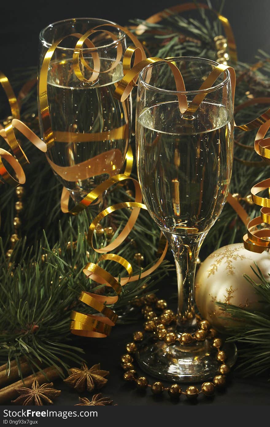 Two glasses full of champagne and pine trees with New Year decoration. Two glasses full of champagne and pine trees with New Year decoration