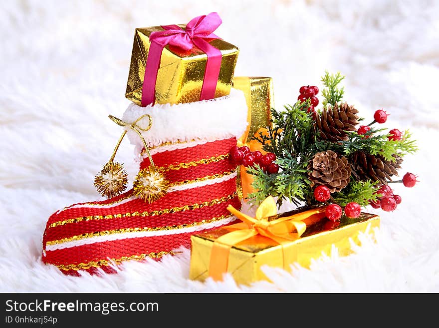 Merry Christmas composition. Santa`s shoe with gift boxes on billowy feathers with snow and snowflakes. Happy holidays.