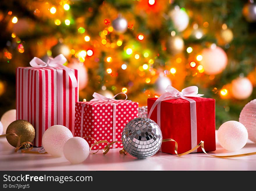 Christmas presents and balls against the backdrop of a festive Christmas tree