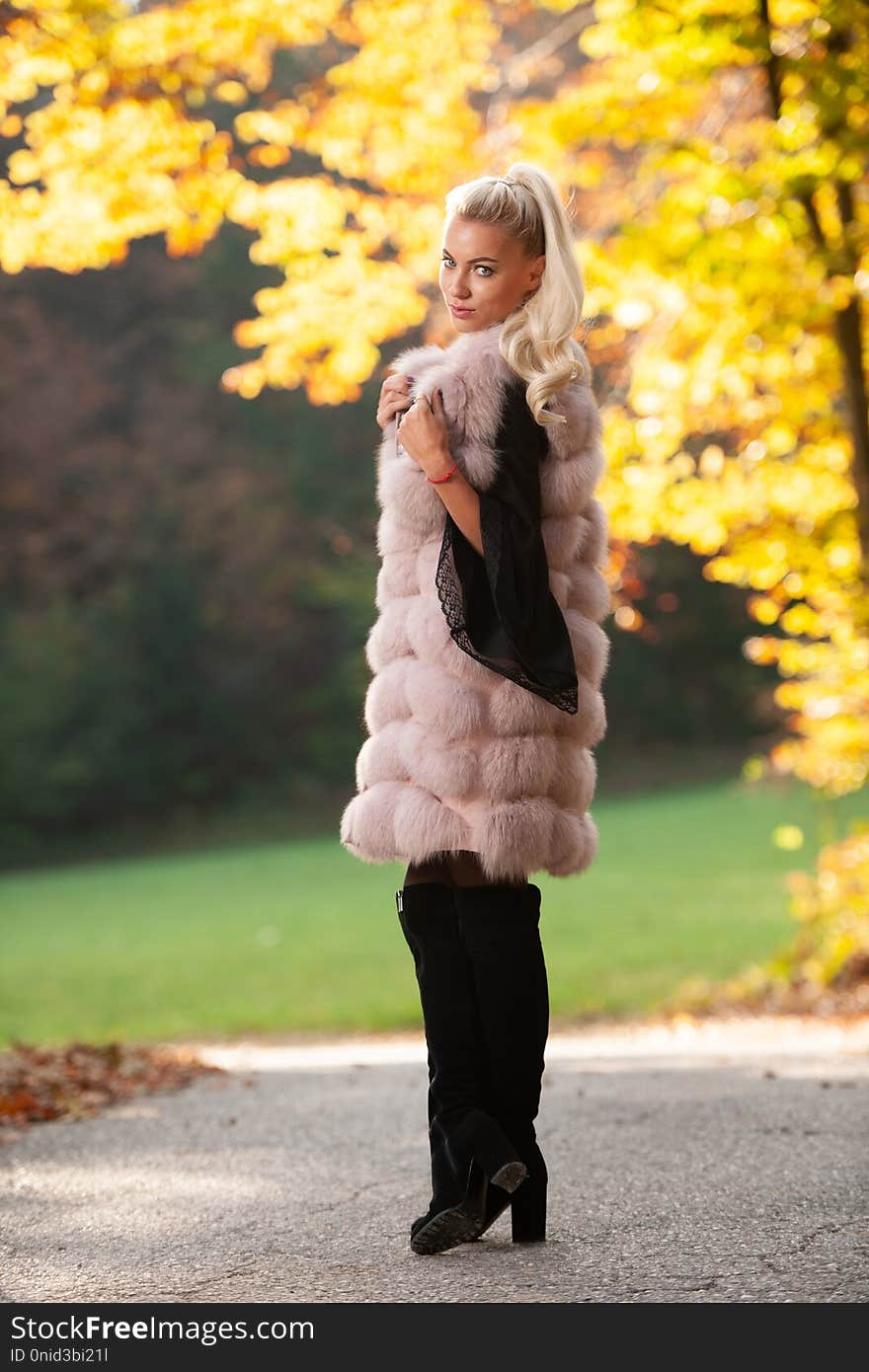 Beautiful stylish woman pose in park in early autumn