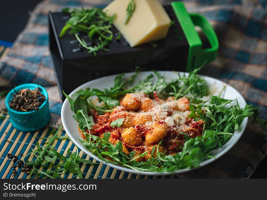 Gnocchi in plate with arugula, cheese and spices. Gnocchi in plate with arugula, cheese and spices