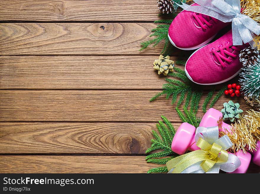 Fitness and Healthy Christmas sport composition. Flat lay of sport shoes, dumbbells and bows. Merry christmas and Happy new year