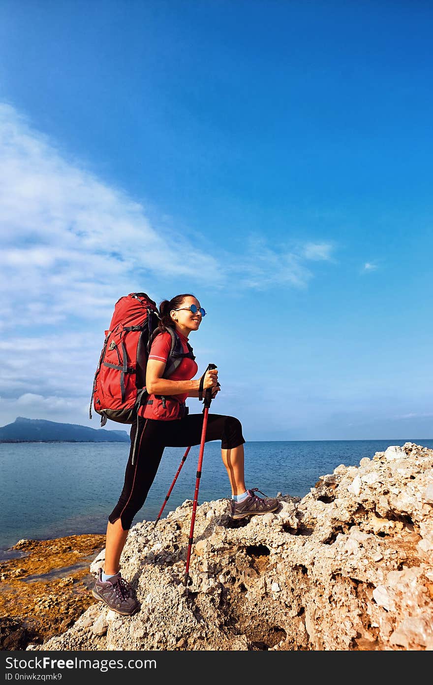 Adventure trek along the coast with a backpack in the summer