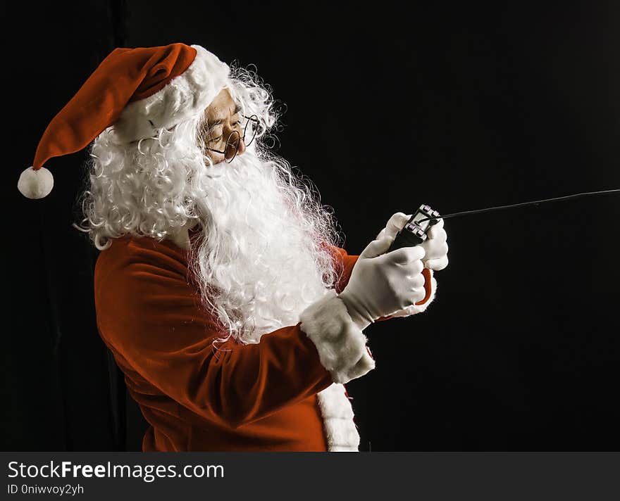 Santa Claus playing game studio shot on black background for family, giving, season, Christmas, holiday, new year, travel, Christian and gathering concept