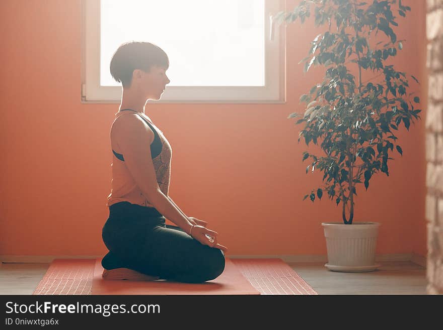 Side view of woman doing yoga training at home