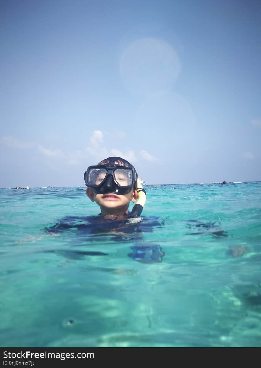 Child wearing snorkeling mask in the crystal clear emerald sea water. Child wearing snorkeling mask in the crystal clear emerald sea water.