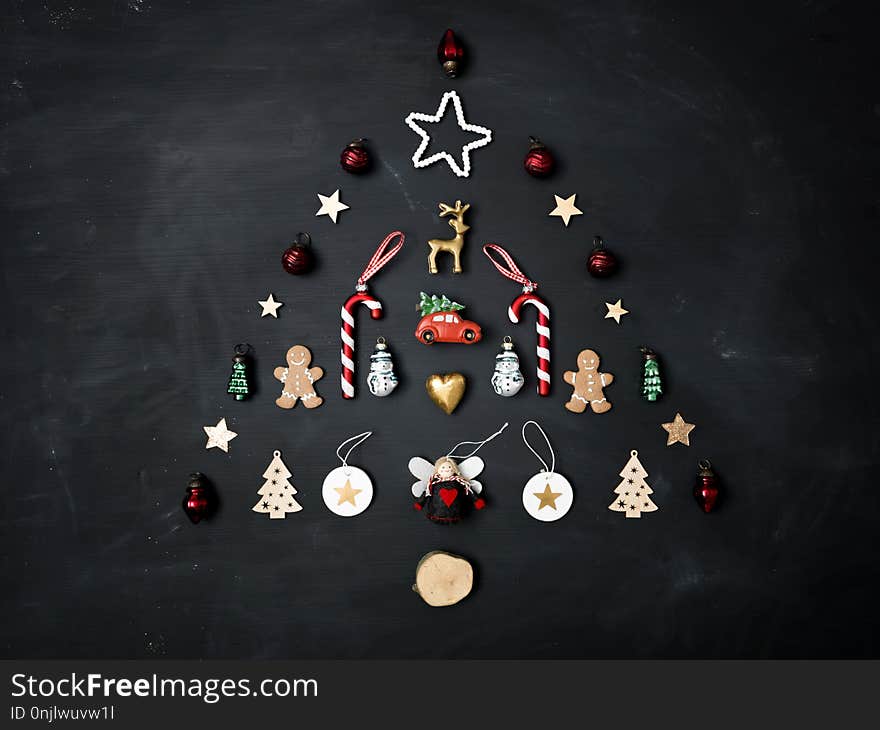 Christmas tree shaped out of different Christmas deco items, on black chalkboard