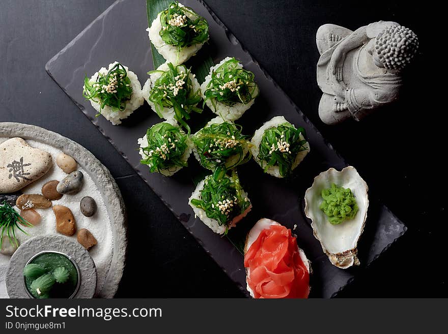 Top View Of Healthy Green Sushi Rolls Served With Wasabi And Pickled Ginger. Near On The Table Two Pots With Succulents.