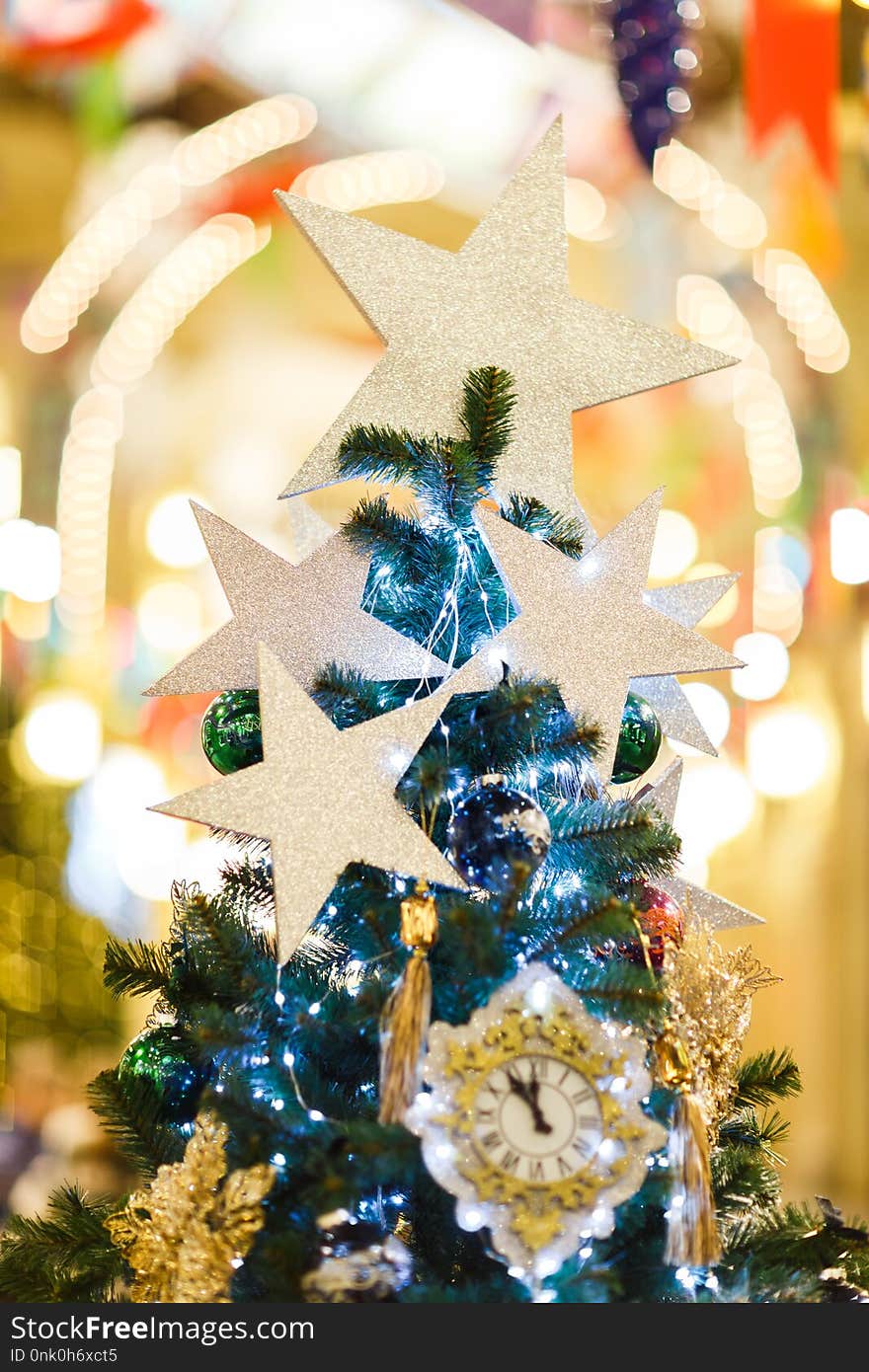 Photo of decorated Christmas spruce with clock, blue balls in store, defocused background. Photo of decorated Christmas spruce with clock, blue balls in store, defocused background.