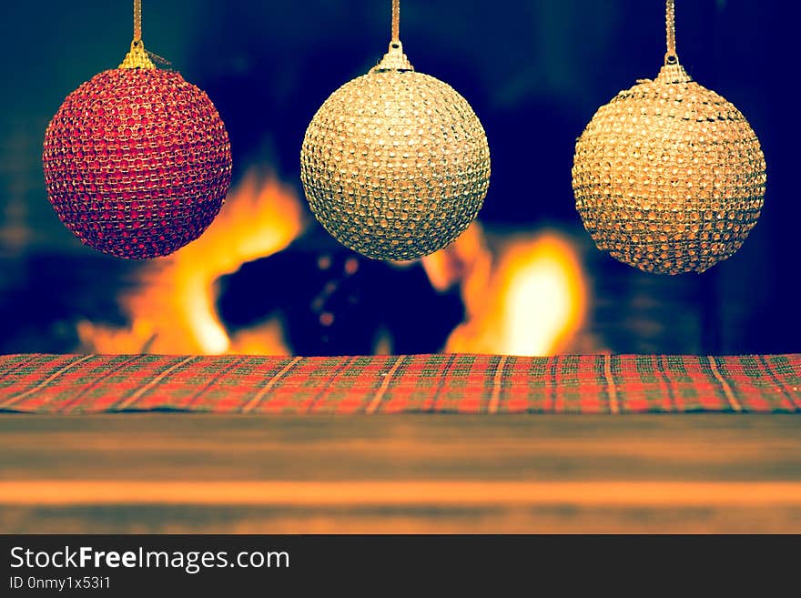 Christmas decoration on wooden table with blurred fireplace in the background. Christmas decoration on wooden table with blurred fireplace in the background.