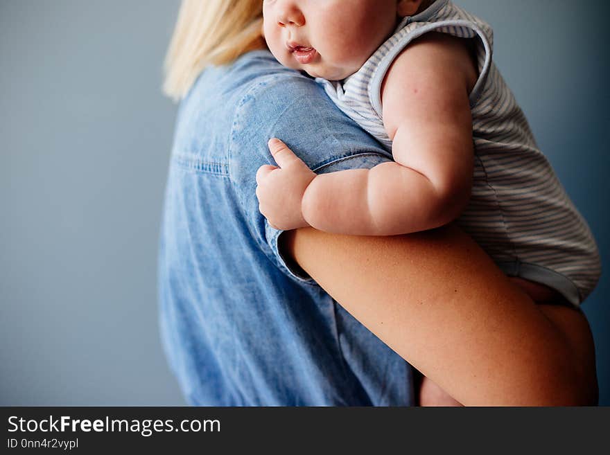 A small baby boy in the arms of his young mother. A small baby boy in the arms of his young mother.