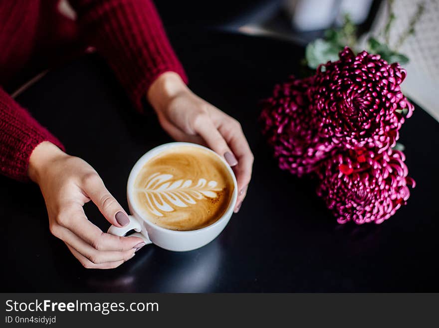 Close up of beautiful female hand holding big white cup of cappuccino coffee. Close up of beautiful female hand holding big white cup of cappuccino coffee.