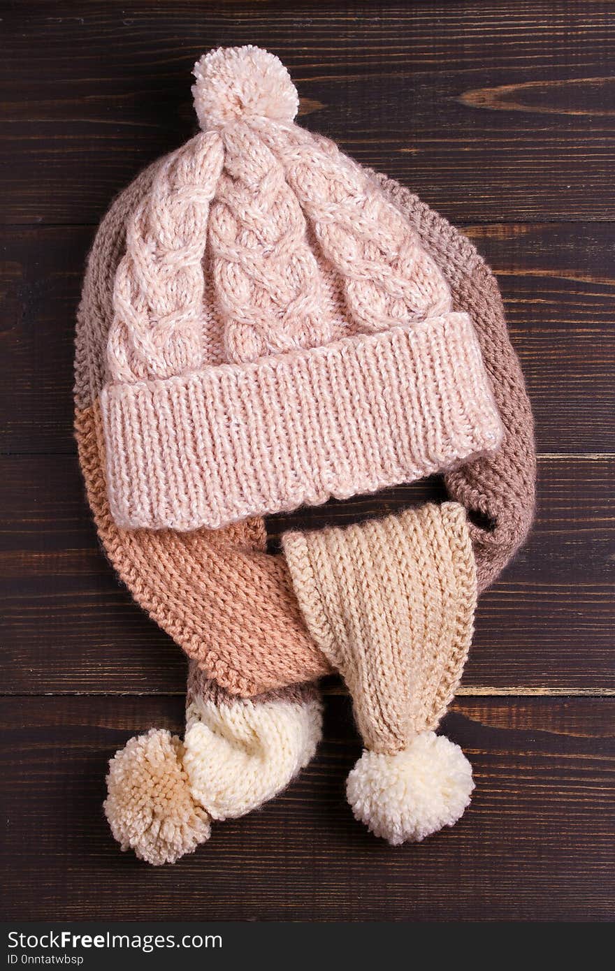 Knitted hat and scarf, winter concept. Women winter warm accessories on wooden background. Flat lay, view from above