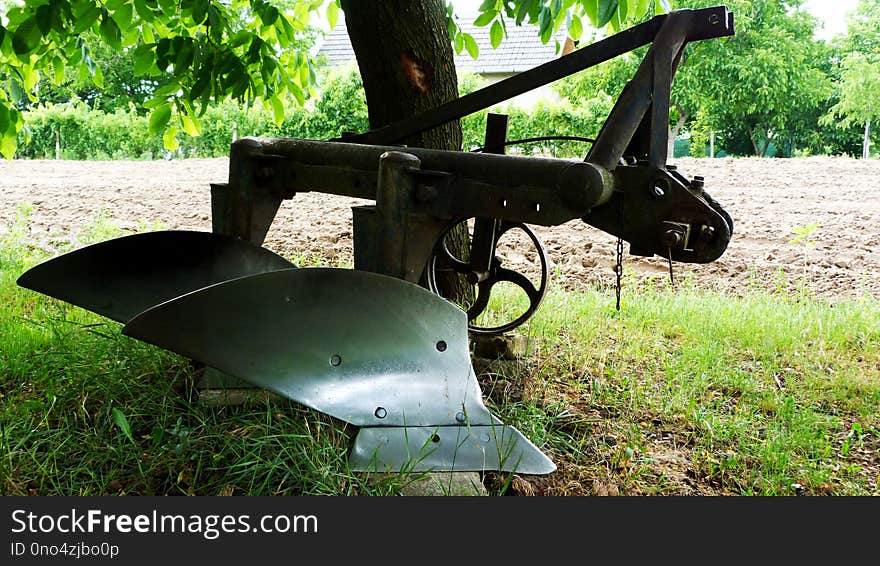 Close-up Of Old Shiny Steel Plough In Rural Setting