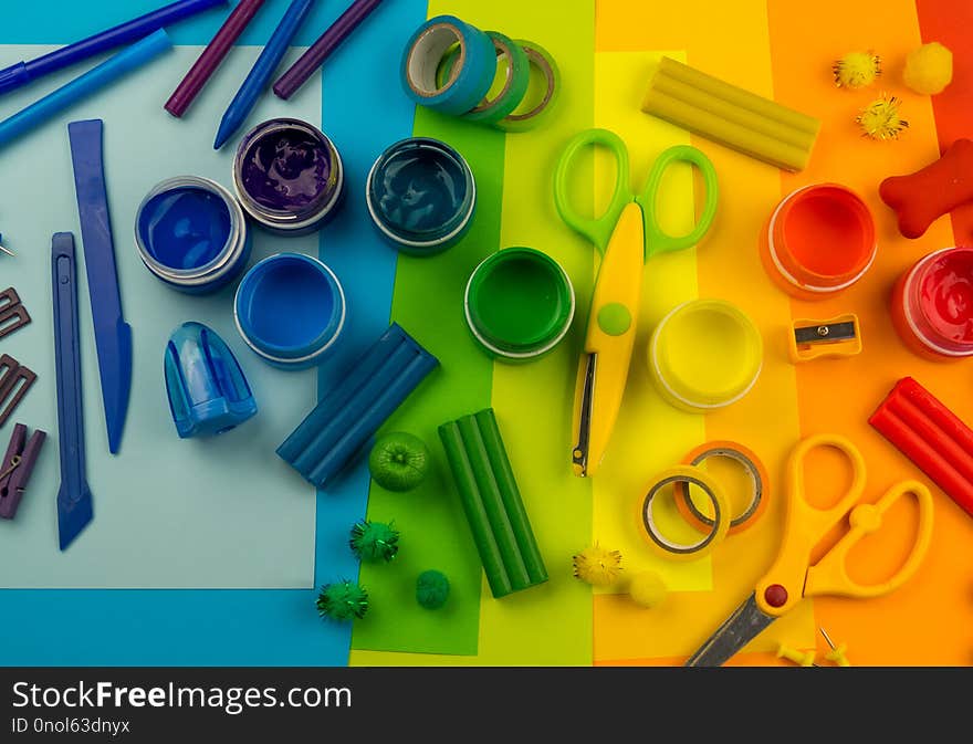 School accessories are laid out in the form of a rainbow. Black background