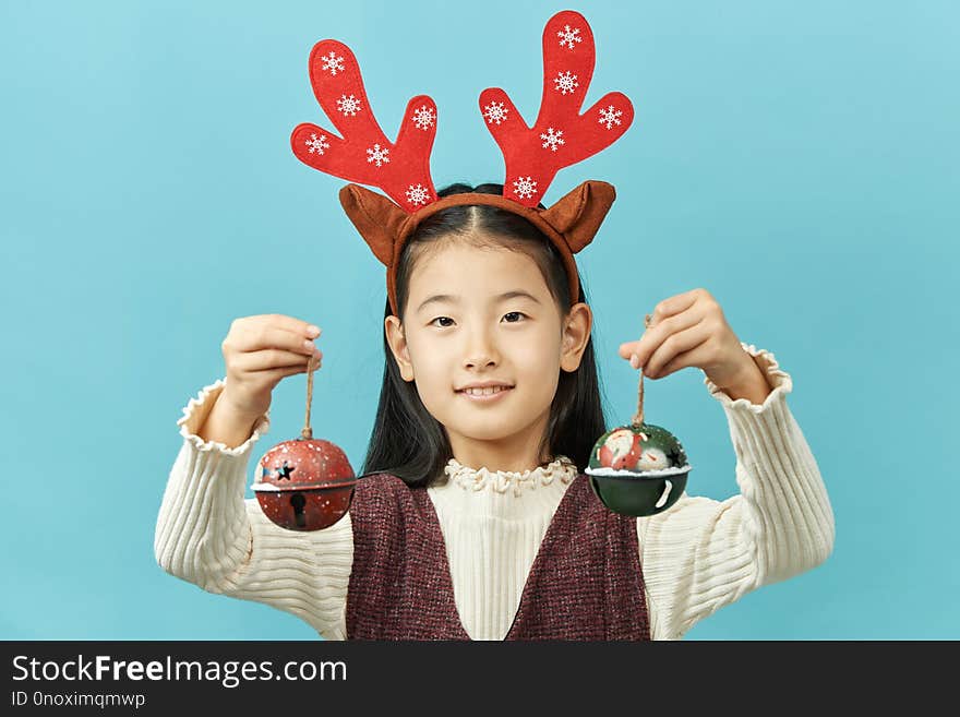 Asian girl with a Christmas concept headdress Child, Close up of cute little asian girl on blue background isolated