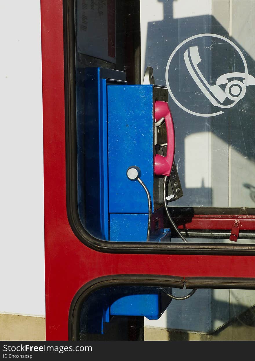 Retro style blue land line public telephone in red booth