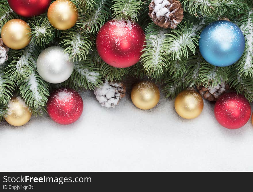 Christmas tree decoration with colored balls under snow as frame