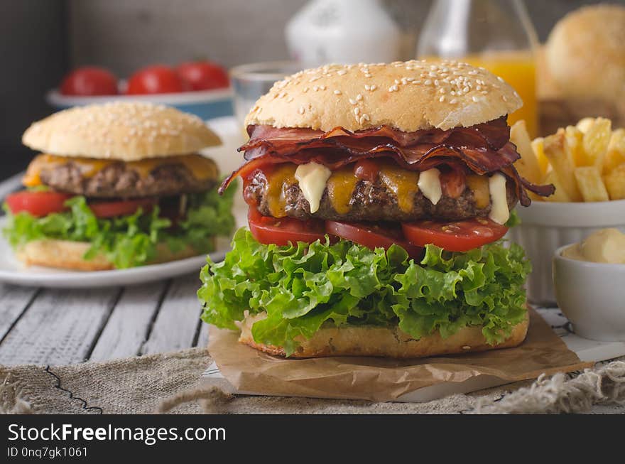 Homemade bacon burger with lettuce and cheddar, homemade potato french fries, food photography