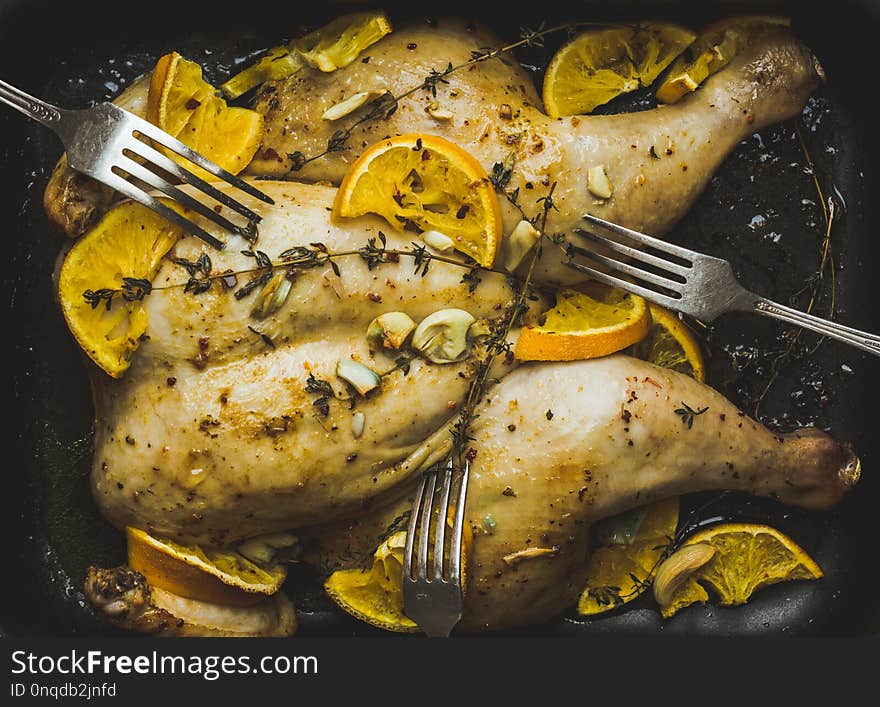 Christmas chicken on the pan with spices and orange slices. Selective focus. Shallow depth of field.