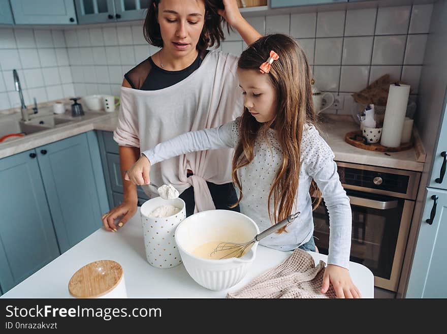 Mom and daughter cook together in the kitchen. Mom and daughter cook together in the kitchen