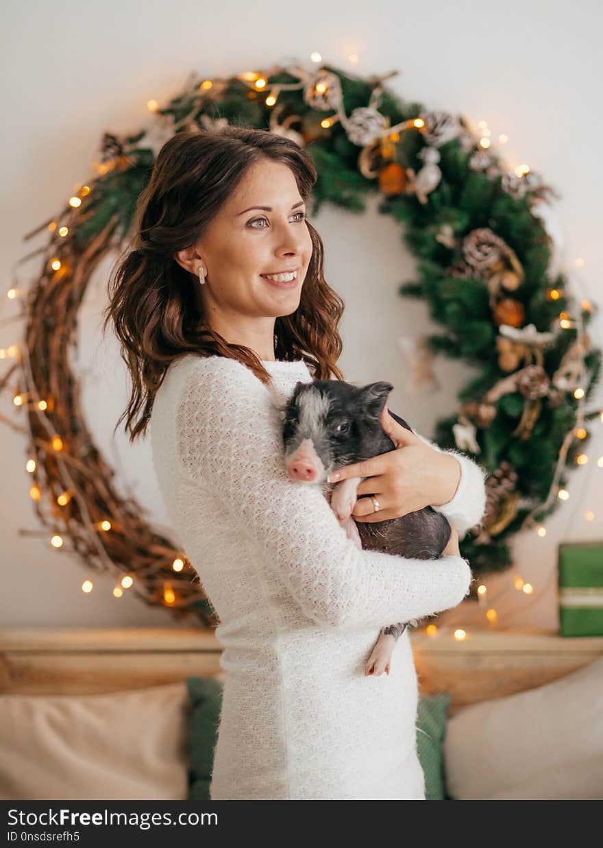 Happy husband and wife in Christmas decorations with black vietnamese piglet. Concept of the Chinese New Year 2019 of the Pig