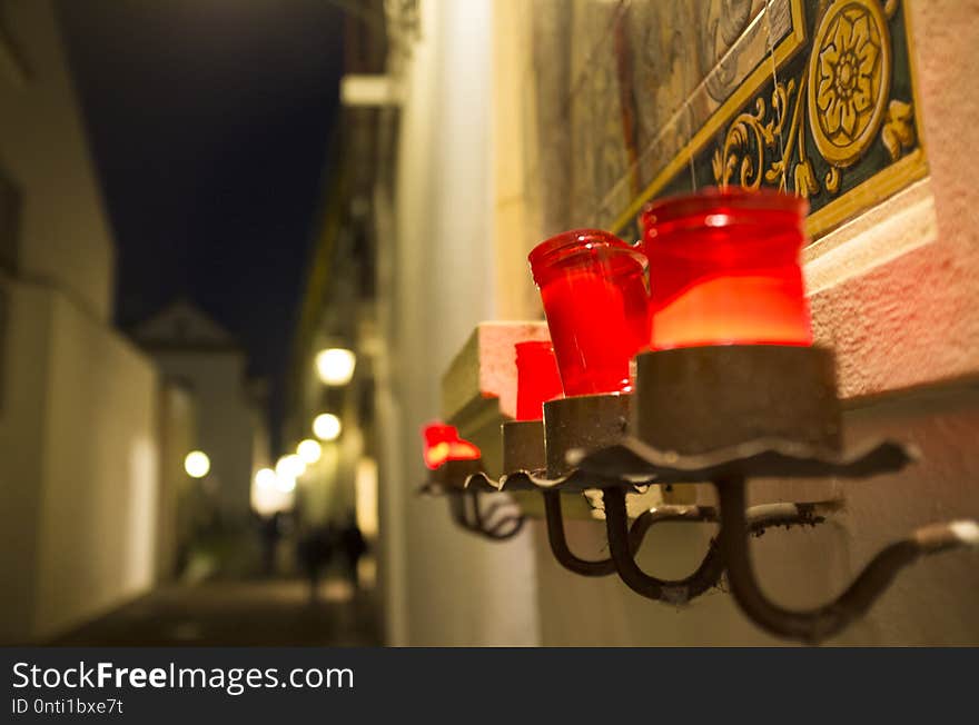 Red candles attached to little altar at night, Cordoba, Spain