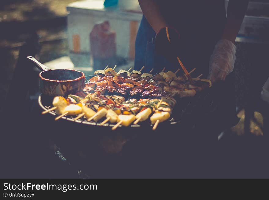 Preparation of barbecue, Grilled skewers on plate outdoor..Grilled shish kebab on metal skewer. Chef hands cooking roasted meat slices barbecue with lots of smoke. BBQ fresh beef chop slices. Traditional eastern dish on charcoal and flame, picnic, street food