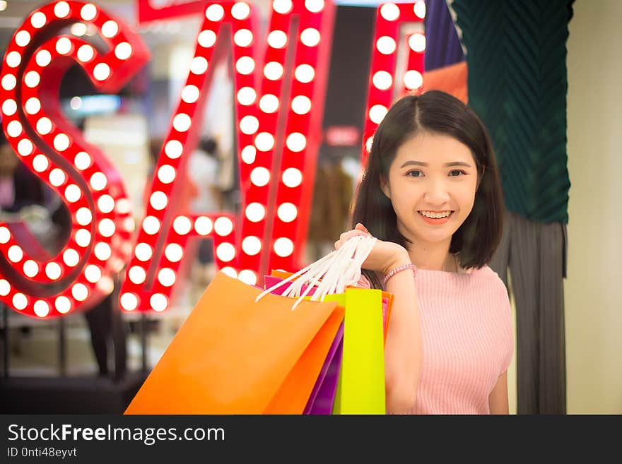 Young Woman holding fashion shopping bag in mall, close up. Young girl with beauty fashion concept
