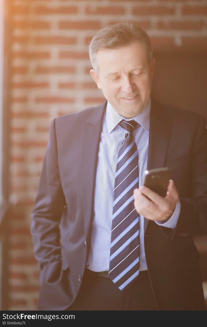 Senior businessman reading text message on smartphone.people and technology