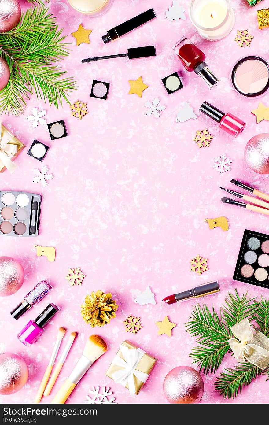 Make up cosmetics, presents and Christmas decorations on artistic pink background, copy space