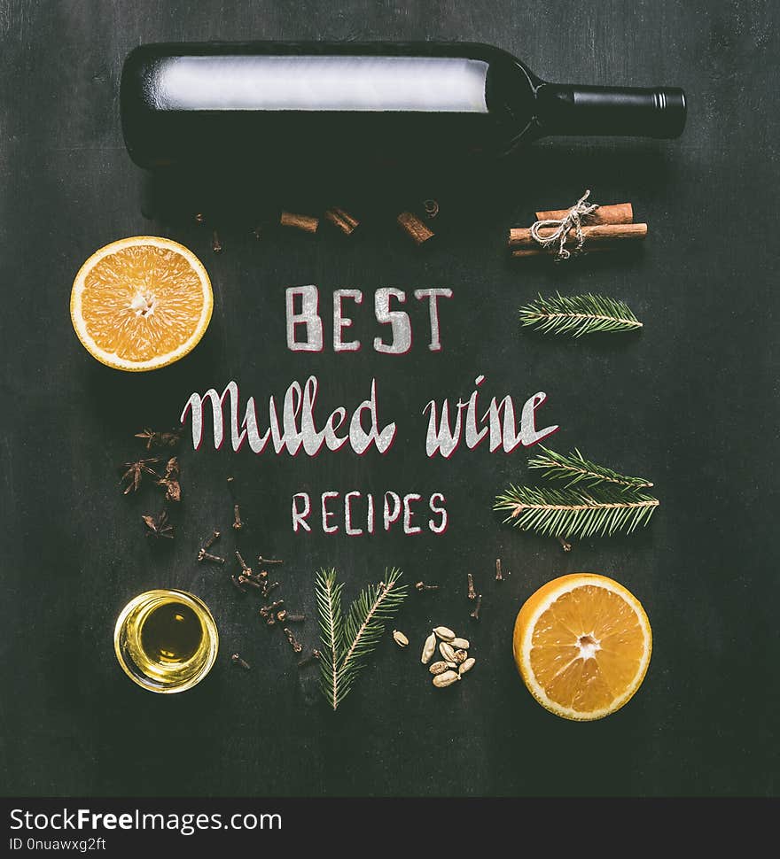 Christmas mulled wine preparation, a bottle of wine, oranges, seasonings and spices, anise and cinnamon, on a black wooden background flat lay. Christmas mulled wine preparation, a bottle of wine, oranges, seasonings and spices, anise and cinnamon, on a black wooden background flat lay