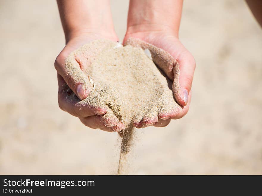 Hand with sand. Hand sand down gently on the beach. Hand with sand. Hand sand down gently on the beach