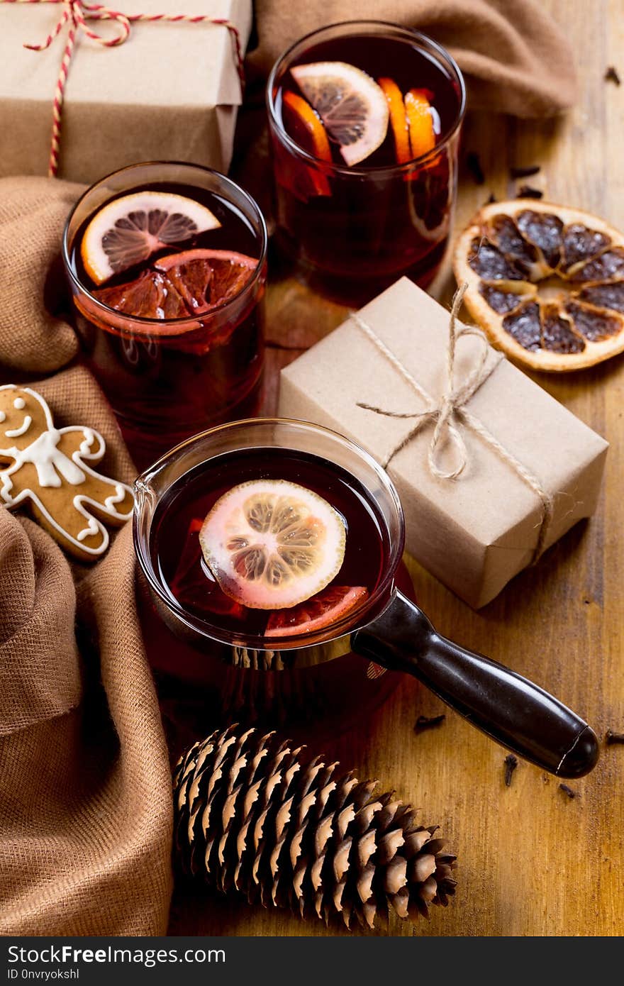 Mulled wine in glass mug with spices. Christmas hot drink on wooden table. Top view.