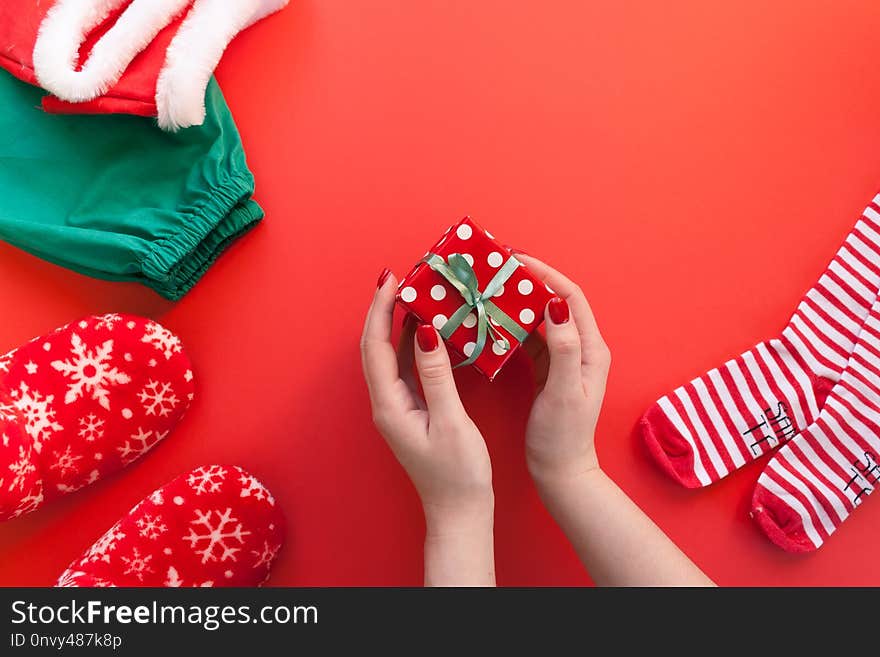 Women`s hands holding a gift on a red background. Women`s hands holding a gift on a red background