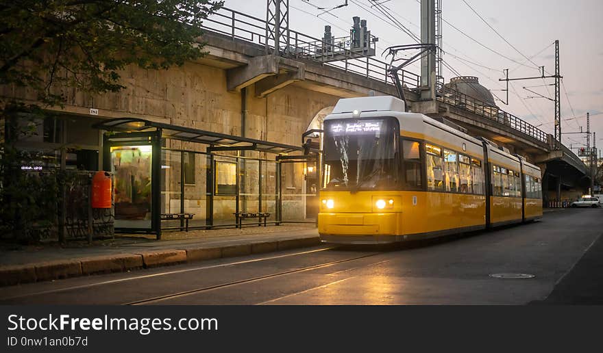 Public transportation concept. Yellow electric tram at Berlin, Germany. Cloudy sky background