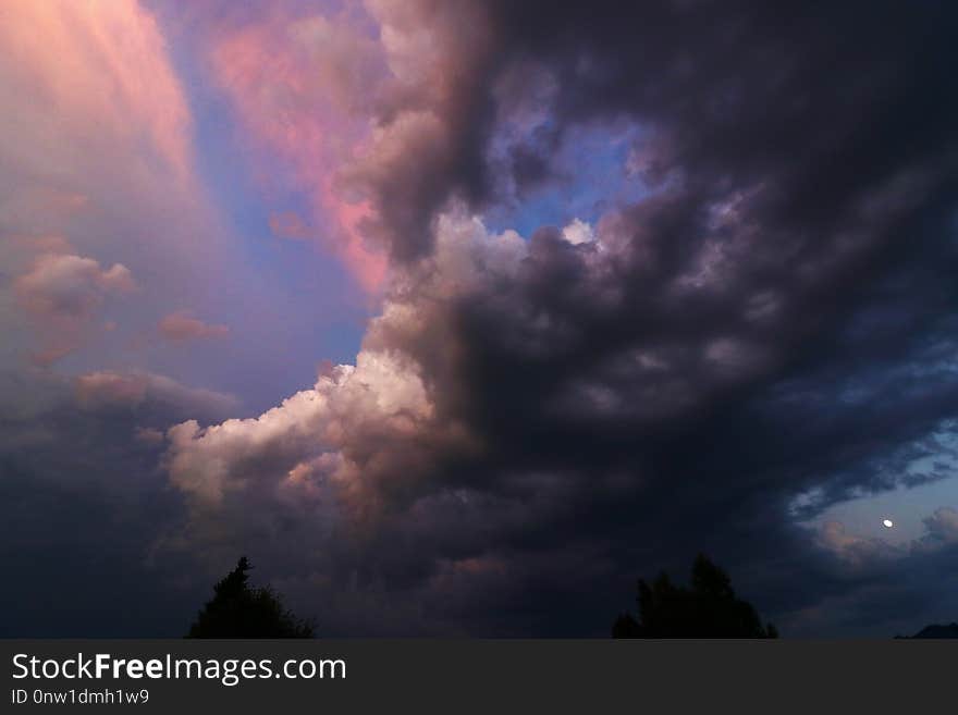 A sunset with coloured and dark clouds. Sundown with thunderclouds