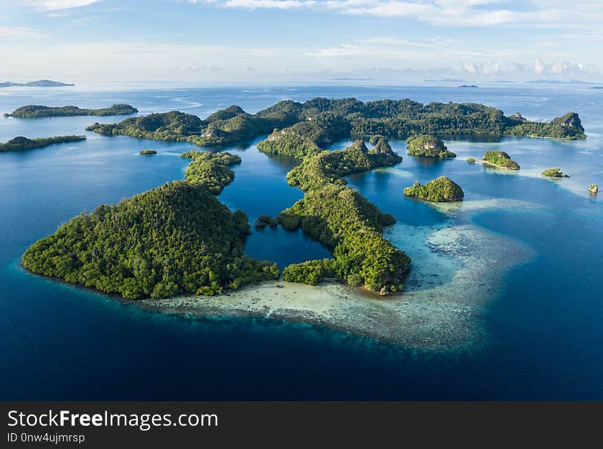 Remote limestone islands in Raja Ampat, Indonesia, are surrounded by healthy coral reefs. This biodiverse region is known as the `heart of the Coral Triangle` due to its amazing marine life. Remote limestone islands in Raja Ampat, Indonesia, are surrounded by healthy coral reefs. This biodiverse region is known as the `heart of the Coral Triangle` due to its amazing marine life.