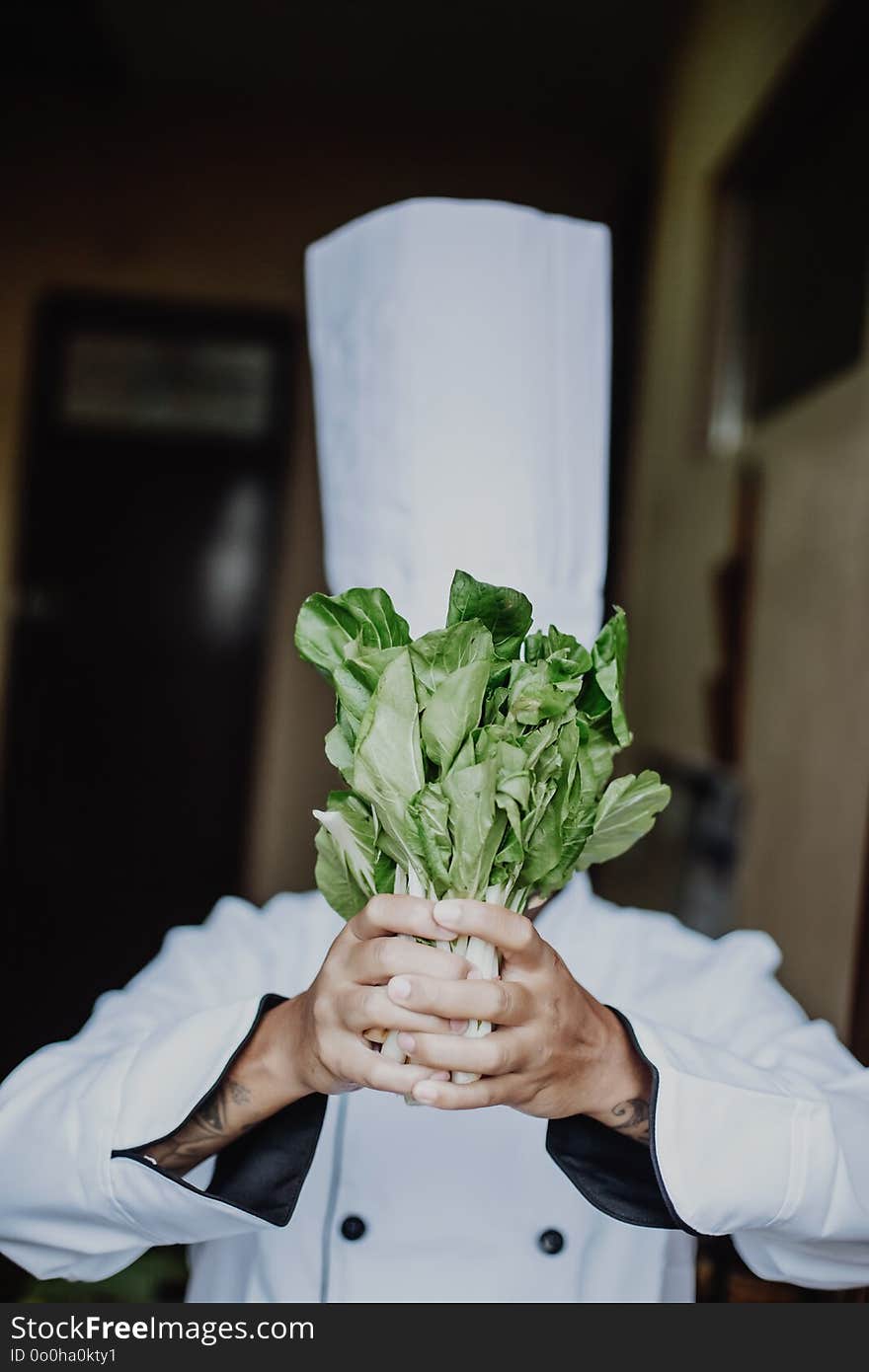 Happy Chef Cooking Healthy meal in an Asian Kitchen, White Hat and White Chef uniform. Happy Chef Cooking Healthy meal in an Asian Kitchen, White Hat and White Chef uniform