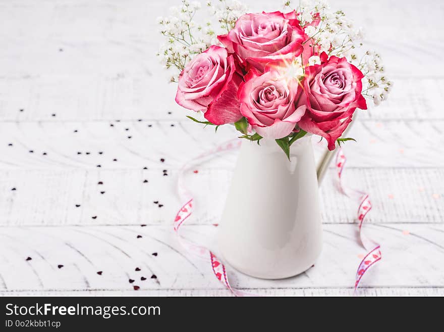 Pink roses in a white pitcher. Valentines day greeting card. Copy space