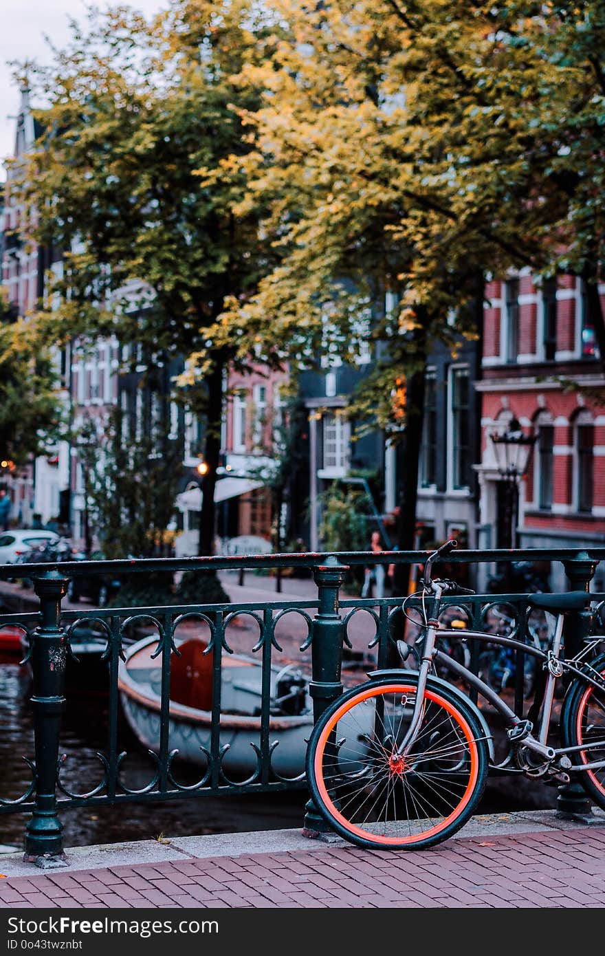 Bike parked on a bridge in Amsterdam, Netherlands. Typical cityscape.