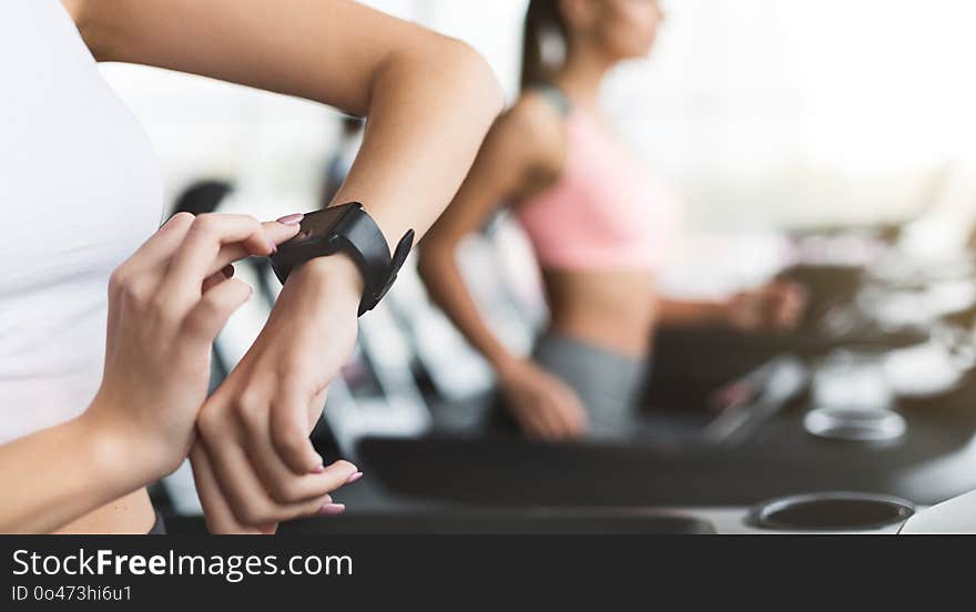 Sportswoman looking at smartwatch with blank screen at gym, crop, copy space