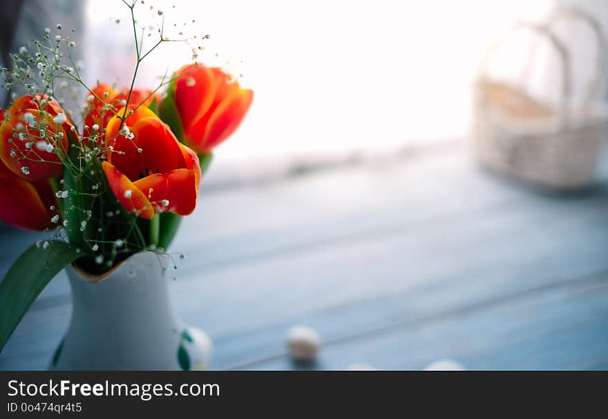 Tulips in a vase on a blue wooden background.