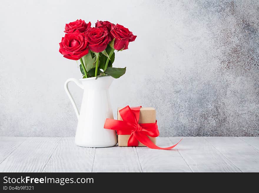 Valentine`s day greeting card with red rose flowers bouquet and gift box in front of stone wall. With space for your greetings. Valentine`s day greeting card with red rose flowers bouquet and gift box in front of stone wall. With space for your greetings