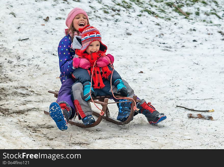 Children enjoy snowshoeing in the snow park where the grass comes out