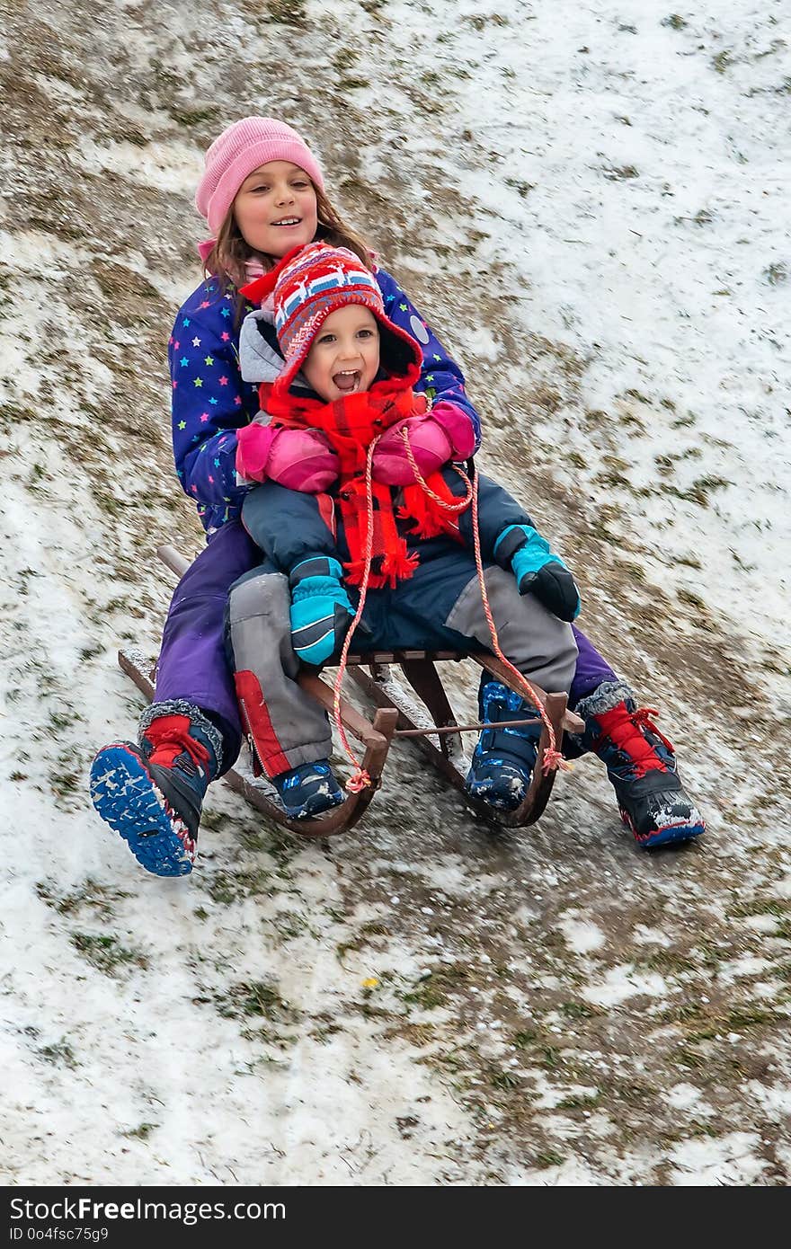 Children Enjoy Snowshoeing In The Snow Park Where The Grass Comes Out