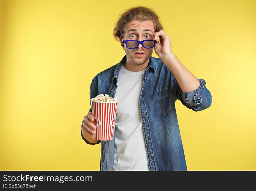 Emotional man with 3D glasses and popcorn during cinema show