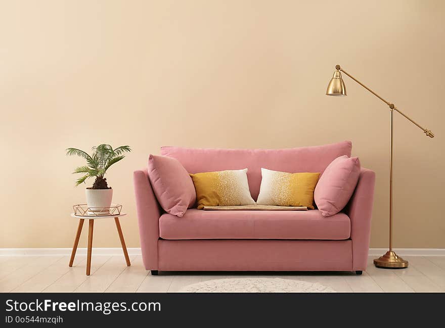 Simple living room interior with modern sofa near color wall. Space for text